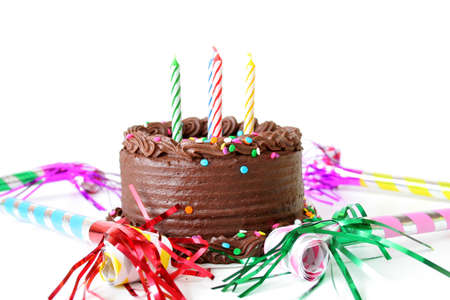 Chocolate Birthday cake with candles and noise makers on a white background.の写真素材