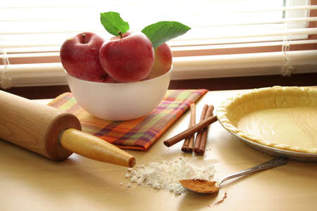 A still life of apple pie makings.  Pie crust, fresh apples, rolling pin and seasonings.  Used special lighting to give this image a special look.の写真素材