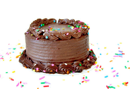 Chocolate birthday cake with sprinkles on a white background with copyspace.の写真素材