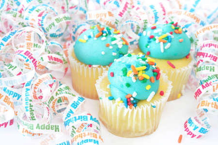 Cupcakes on a white background surrounded by happy birthday ribbons.の写真素材