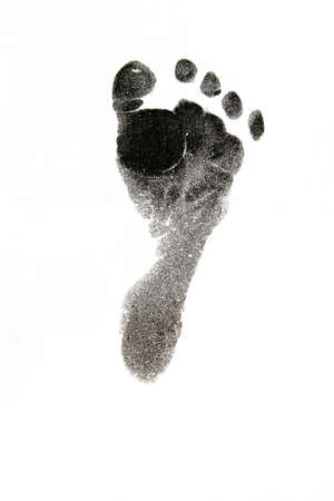New born baby's foot print in black on white background.の写真素材
