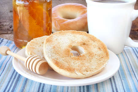 Bagel and honey for breakfast with a cup of coffee.の写真素材
