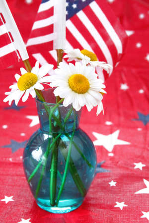 Vase of daises on a red background with stars and flags.の写真素材