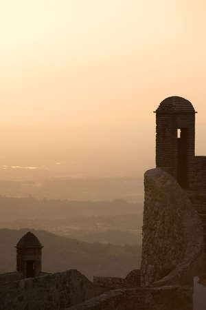 Turrets on the castle of Marvao stand in silhouette over the Alentejo countryside at sunset. Marvao, Portugal. July 17, 2015.のeditorial素材