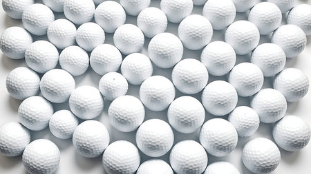 White golf balls arranged in a geometric pattern on a pure white background, emphasizing texture.の素材