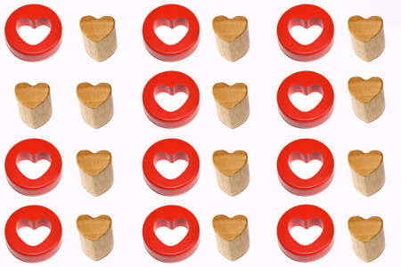 Two identical wooden hearts surrounded by couples of red and wooden hearts