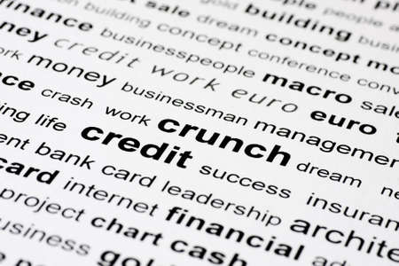 words credit and crunch in black on white background with other financial key words out of focusの写真素材