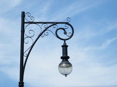 Isolated ornate street light against a blue sky background