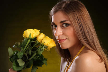 Beautiful woman with a bouquet yellow rose flowersの写真素材