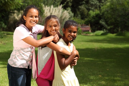 Happy laughter and hugs from three school friendsの写真素材