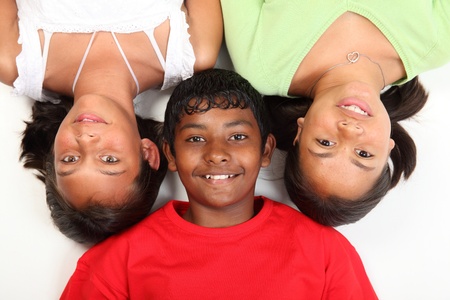 Three teenage friends lying on studio floor boy and two girlsの写真素材