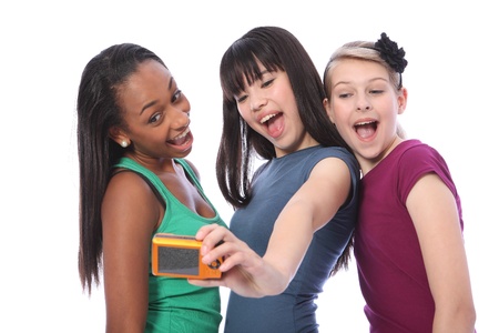 Fun photography with digital camera for three pretty young teenager girl friends a blonde caucasian, an oriental Japanese and an African American mixed race student all having a laugh together.の写真素材