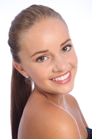 Long brown hair ponytail and big happy smile of cheerful young caucasian teenager girl with beautiful brown eyes, taken against white background.の写真素材