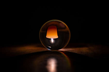 Candle light through a glass sphereの写真素材