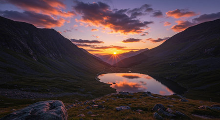 Sunset in the mountains with a small lake in the foreground.の素材