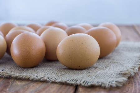 The brown chicken eggs on the wooden table. Side view.の写真素材
