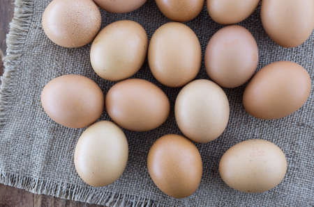 The brown chicken eggs on the wooden table. View from aboveの写真素材