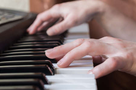 Woman hands playing piano music. Angle view.の写真素材