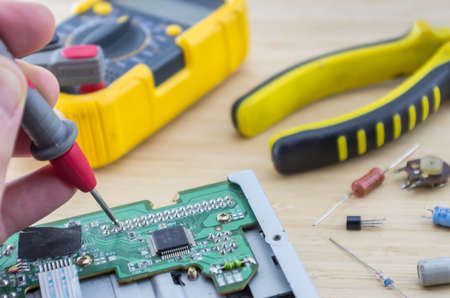 The workplace of serviceman. Hand holding the tester. Angle view