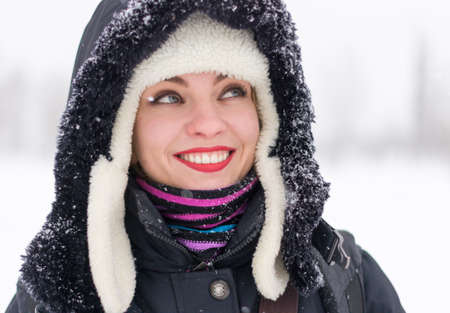 Closeup portrait of young happy woman in the earflaps and hoodの写真素材
