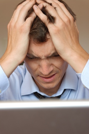 A frustrated businessman sitting at his laptopの写真素材