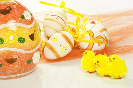 Yellow toy chicks and decorated eggsの写真素材