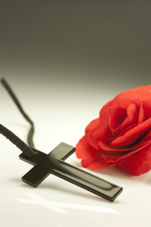 black crucifix with a red flowerの写真素材