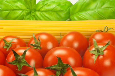 red tomatoes and green leaves of basil with spaghettiの写真素材