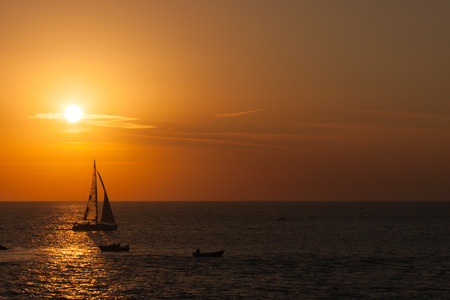 silhouette of a sail boat against sunsetの写真素材