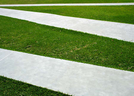 Green grass, concrete paths criss crossの写真素材