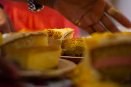 hand picking up a piece of cake among other pieces of cakeの写真素材