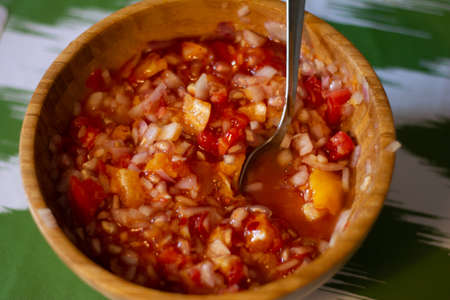 tomato and granadilla salad in a natural bamboo bowlの写真素材