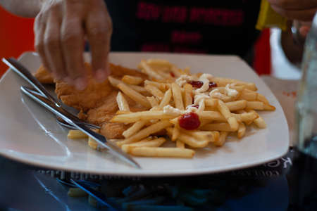 almost empty white plate of elongated yellow fries
