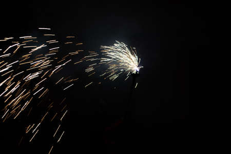 large sparks with many small sparks on a black background with smokeの写真素材