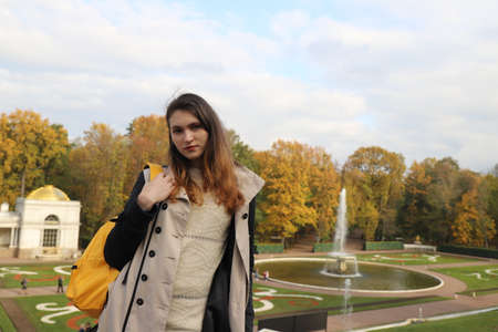 Young girl near beautiful fountains of Saint-Petersburg on a sunny autumn dayの写真素材