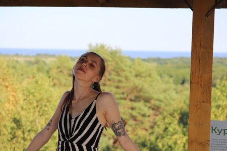 portrait of a young woman on a background of treesの写真素材
