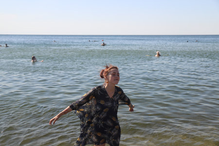 girl in swimsuit walking on the beachの写真素材