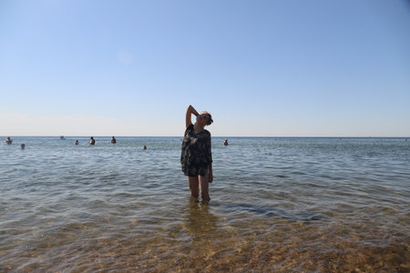 girl in swimsuit walking on the beachの写真素材