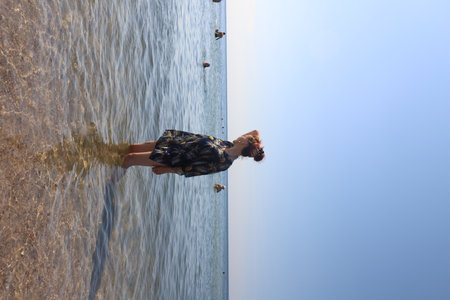 girl in swimsuit walking on the beachの写真素材