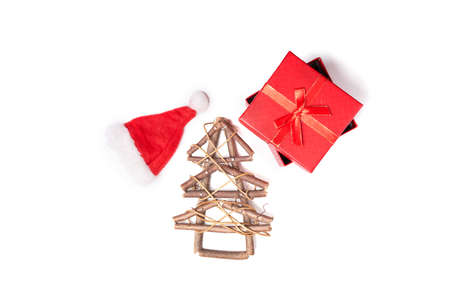 Wooden Christmas tree, xmas cap and red gift on white isolated background with copy spaceの写真素材