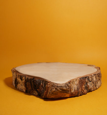 Product display in the form of a birch cut on yellow background, natural podium for your productの写真素材