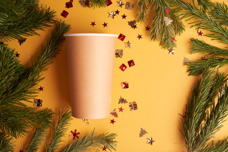 Coffee paper cup on yellow background with confetti and fur, Christmas mockup . High quality photoの写真素材