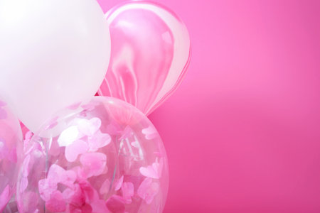 Pink and white balloons with helium on a pink backgroundの写真素材