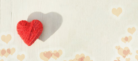 Red heart made of wool threads on a light wooden background. High quality bannerの写真素材