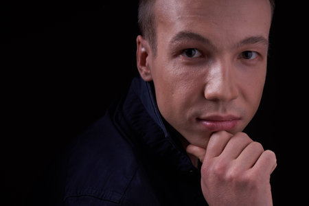 Close up portrait of a beautiful confident young man on a black isolated background in a Studio with...