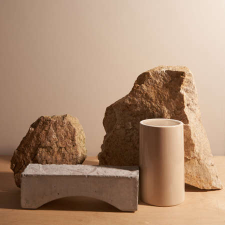 Beige stone and a piece of gray podium tile on a beige background, natural background for your productの写真素材