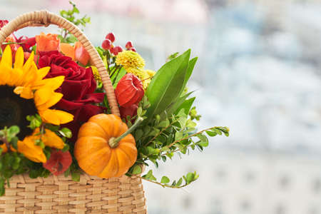 Mixed autumn flowers, sunflower, pumpkin, rose, physalis in basket, bouquet is on the windowsill with copy space. High quality photoの写真素材