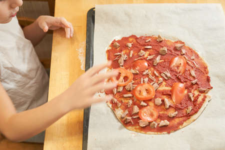 The girl cooking healthy gluten-free pizza with beef. Gluten-free cooking class. Cooking together at home with a parent. Recipe step by stepの写真素材