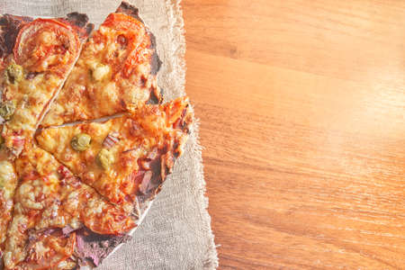 Healthy gluten-free pizza with beef. Gluten-free cooking class. Cooking at home. Pizza on a linen napkin on a wooden background.の写真素材