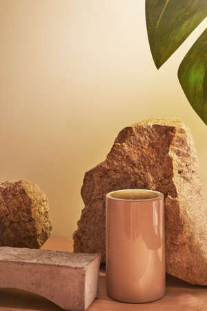Beige natural background with podium for your product, stones and stage for your product demonstration with tropical plant frameの写真素材